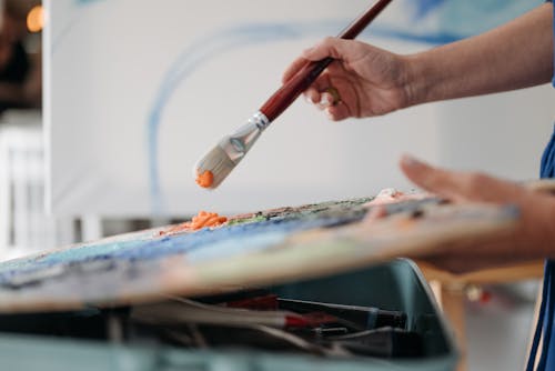 Close-up of Person Holding a Paintbrush and a Palette 