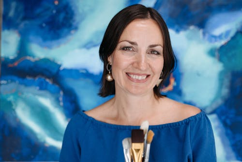 A Woman in Blue Shirt Smiling at the Camera