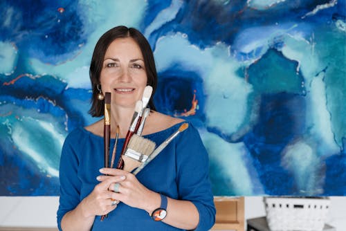 Woman Holding Variety of Paint Brushes
