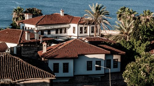 Free Charming coastal town with traditional red-roofed houses and lush palm trees. Stock Photo