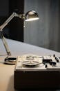 Reel-to-reel Audio Tape Recorder and an Electric Lamp Standing on a Table