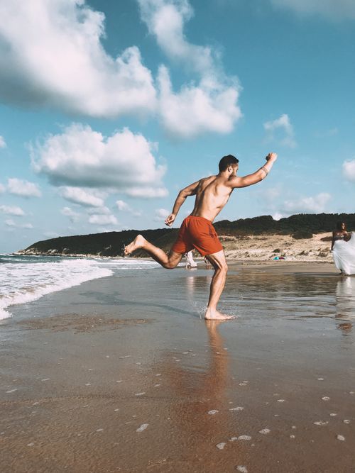 Free A man runs barefoot along the beach in Şile, İstanbul, enjoying the summer sun and sand. Stock Photo