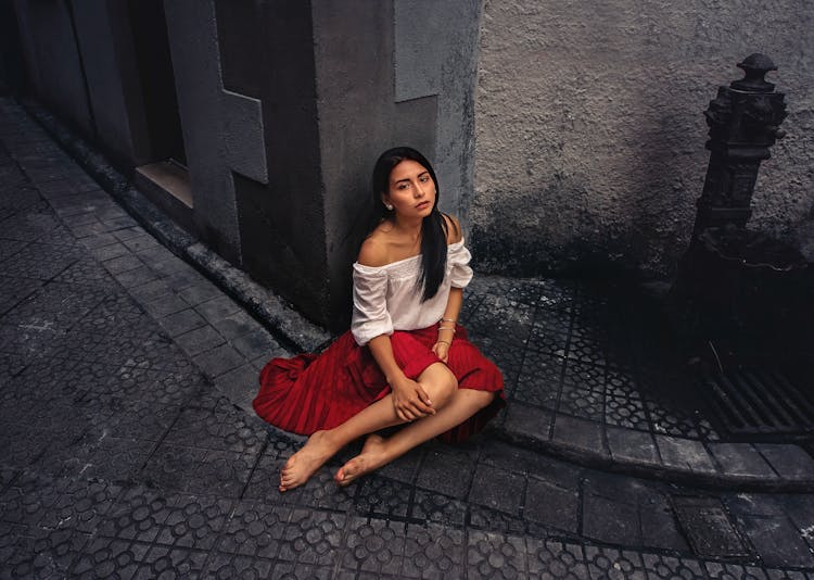 Barefoot Woman Sitting On Sidewalk 