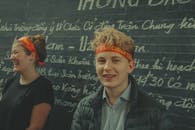 两个年轻人在越南的黑板前微笑