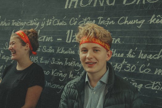 两个年轻人在越南的黑板前微笑