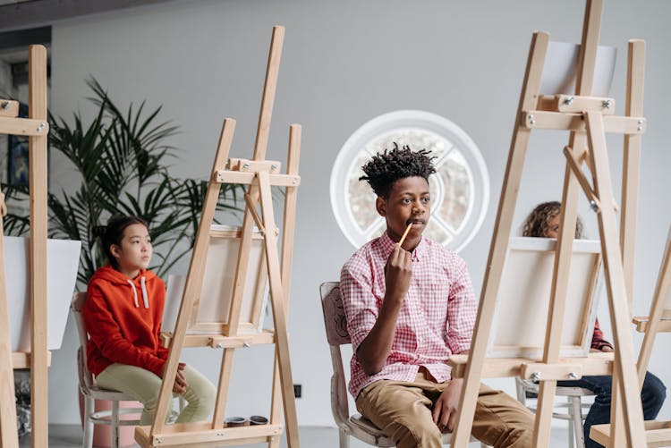 Kids Sitting Beside Wooden Easels