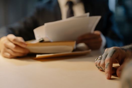 Close-up of business people reviewing documents at a desk, focused on hands and paperwork.