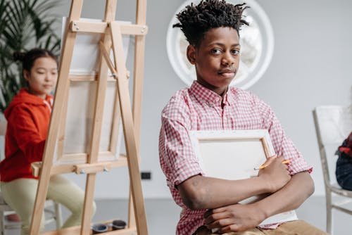 A Boy Holding a Painting Canvas