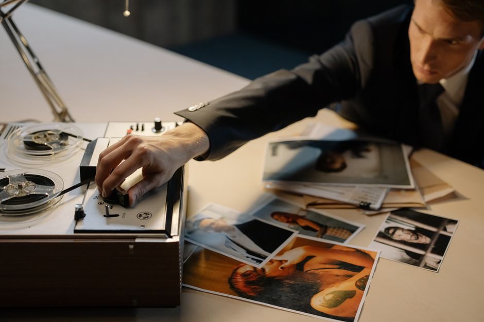 Legal documents and evidence files stacked on wooden desk with magnifying glass