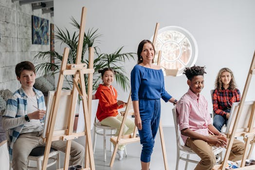 Diverse group of children painting in art class guided by teacher.