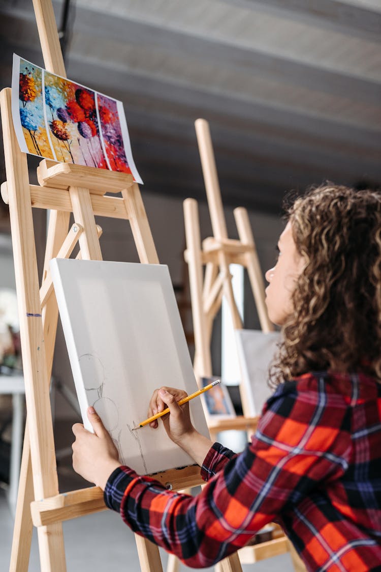 A Girl Painting On The Canvas