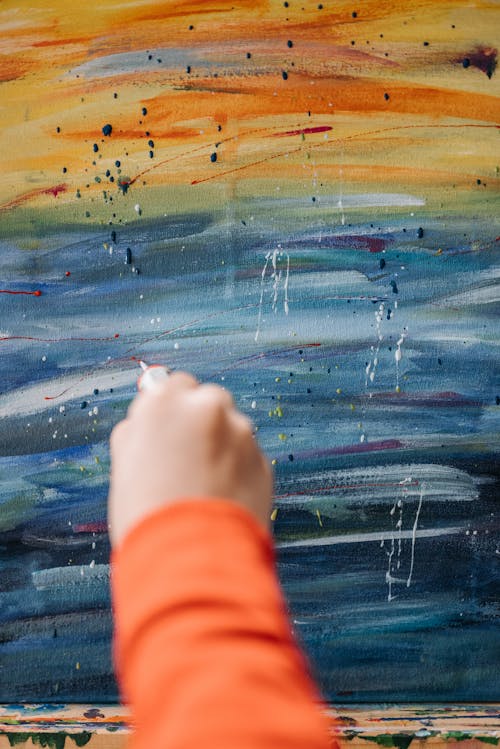 A Person in Orange Long Sleeve Shirt doing Painting