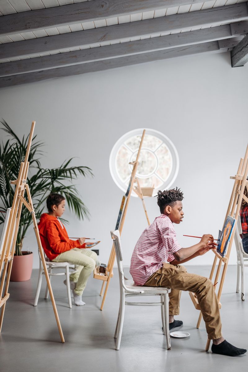 Young artists painting at easels in a classroom