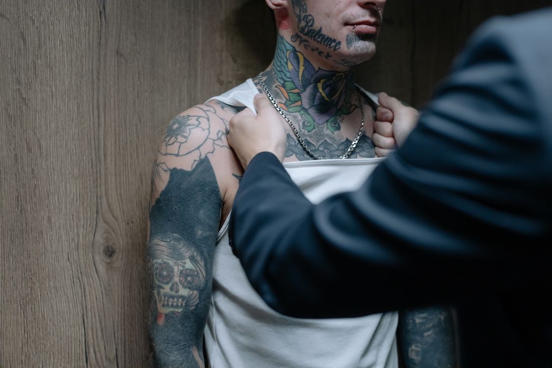 A Person in Long Sleeves Grabbing a Man Wearing White Shirt · Free ...