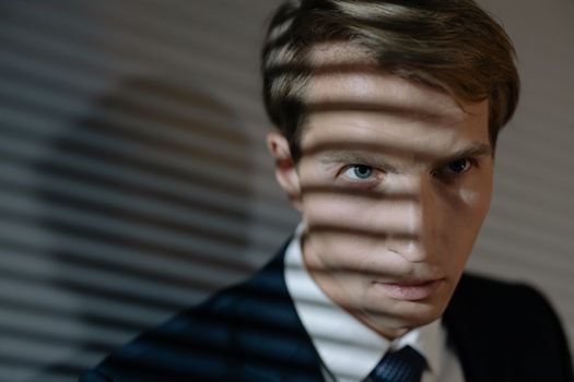 A portrait of a businessman in a suit with dramatic light and shadow effects.