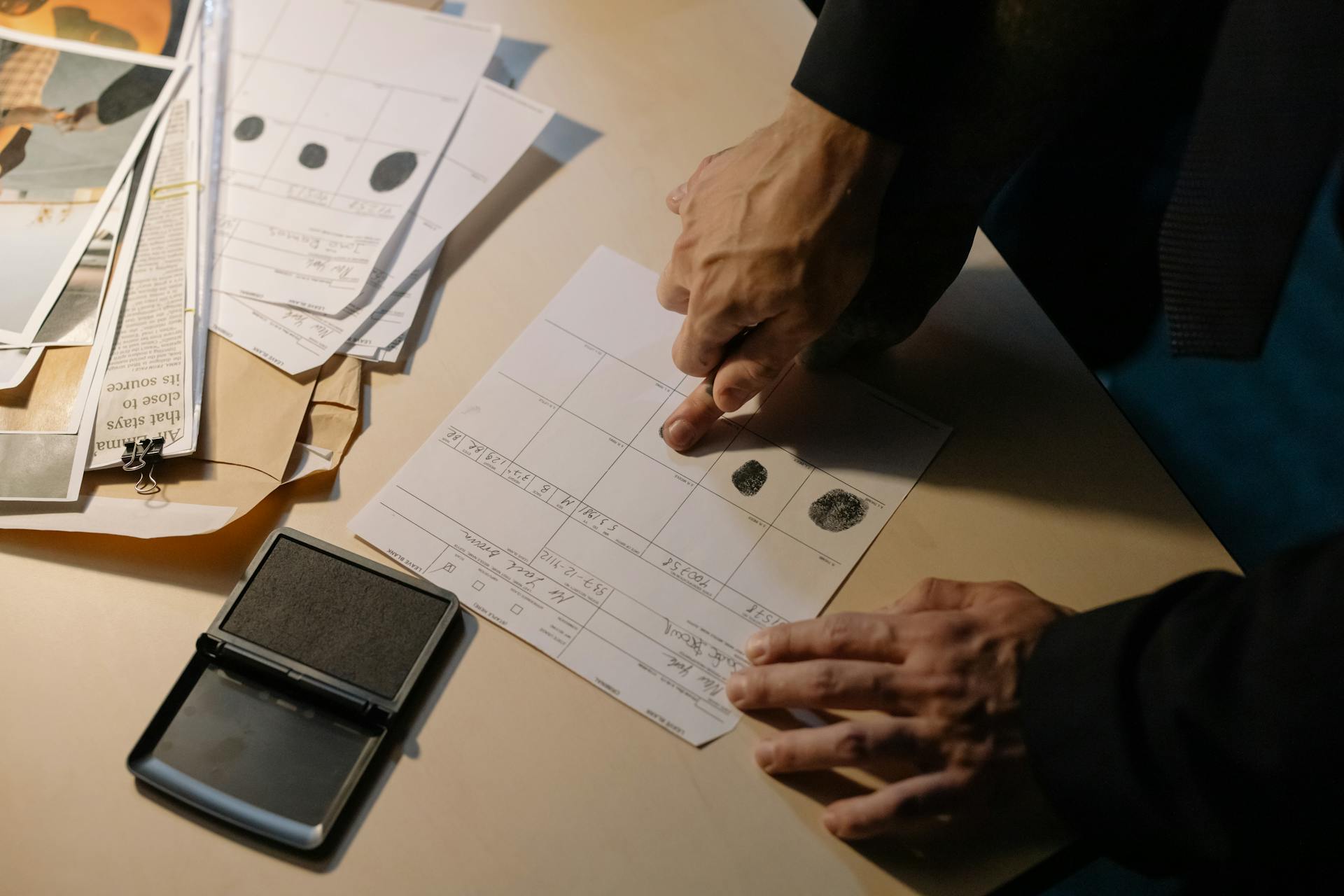 Person in Black Long Sleeve Putting Fingerprint on Paper