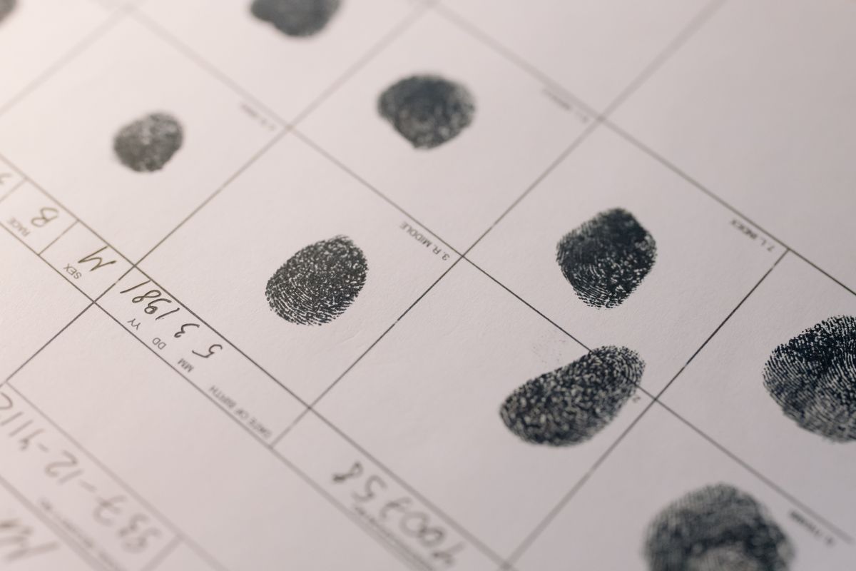 Une main tient un document d'identité à côté d'un smartphone, illustrant une vérification