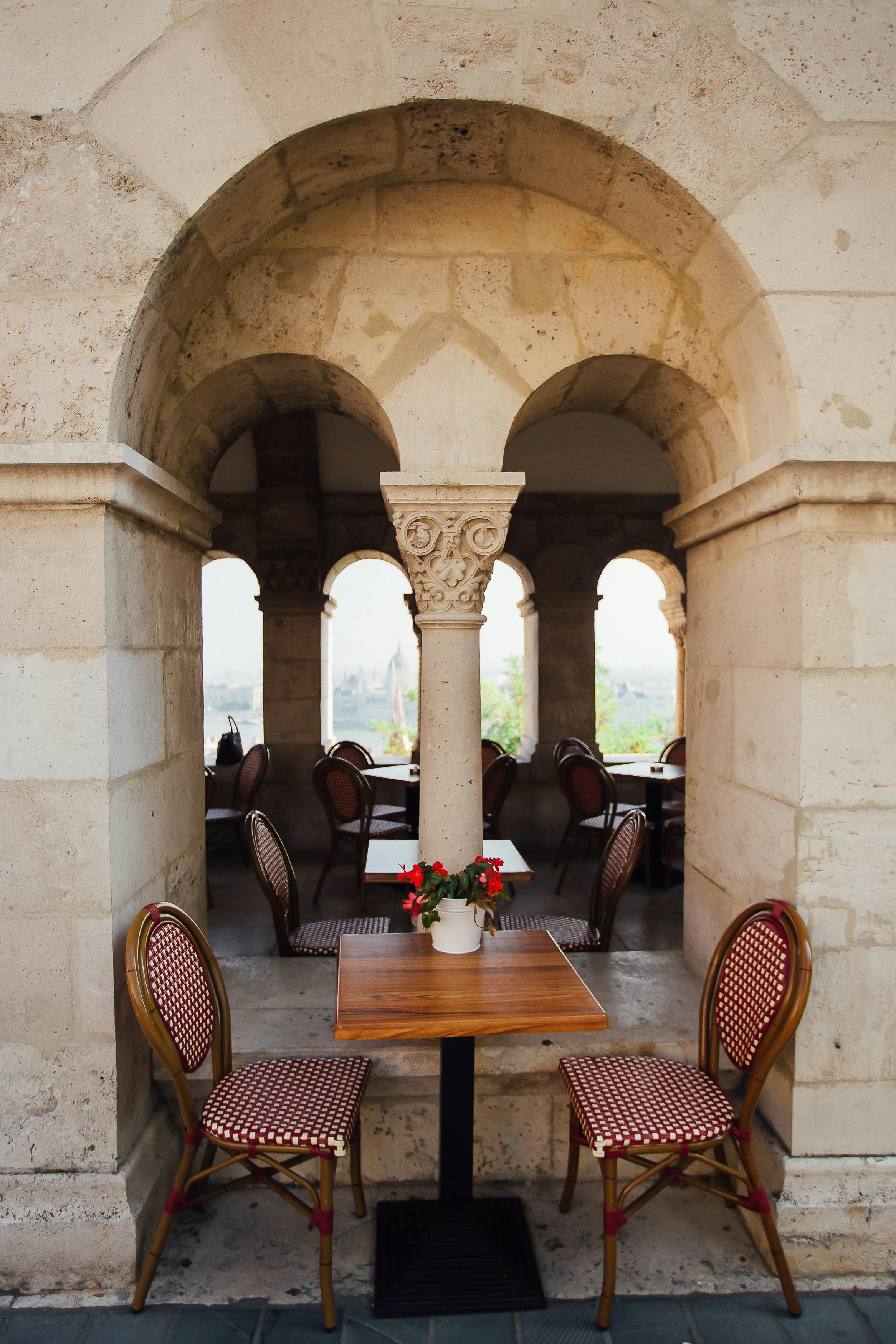 Free A cozy outdoor cafe with beautiful arches and decorative seating. Stock Photo