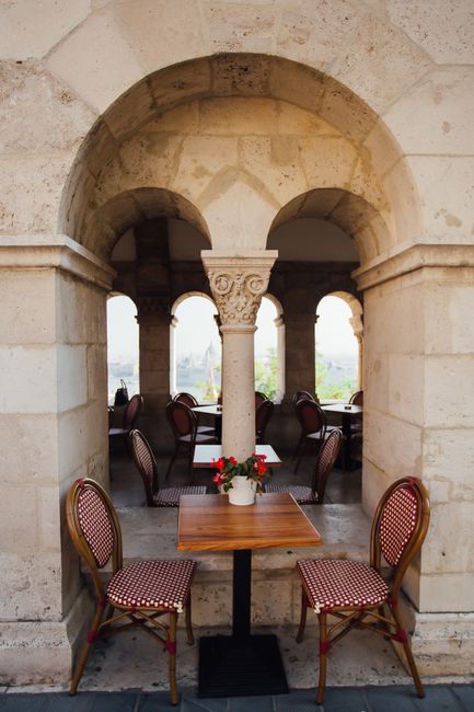 A cozy outdoor cafe with beautiful arches and decorative seating.