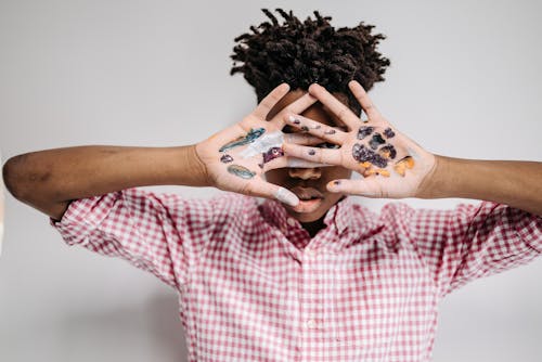 Man Covering His Face With Hands Full of Painting 