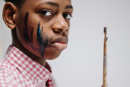 Man With Painting on His Face Holding a Paint Brush 