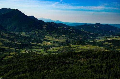 An Aerial Photography of a Green Mountain Under the Blue Sky