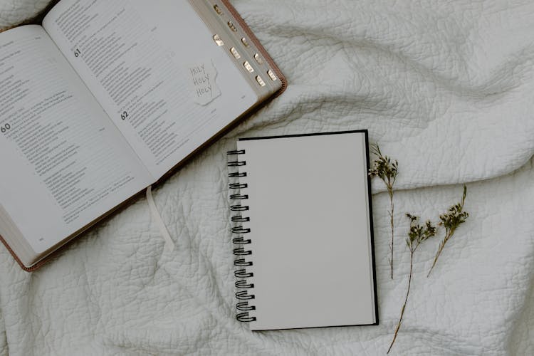 White Notebook Beside A Bible 