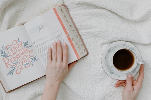 A Person Holding a Book While Having Coffee