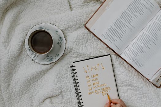 A setting of morning Bible study with coffee, notes, and a quilted fabric backdrop.
