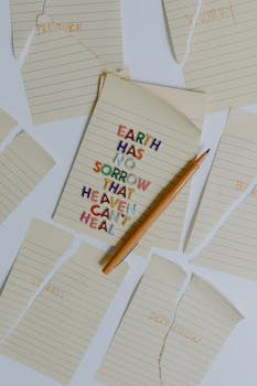 Inspiring message on a notepad with pencil, surrounded by torn paper pieces.