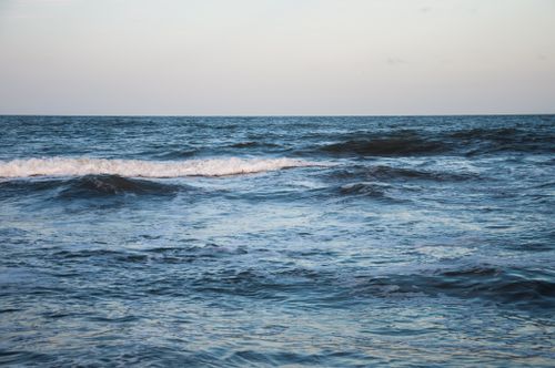 Free Calm ocean waves under a pastel sky at dawn, capturing a serene morning by the sea. Stock Photo