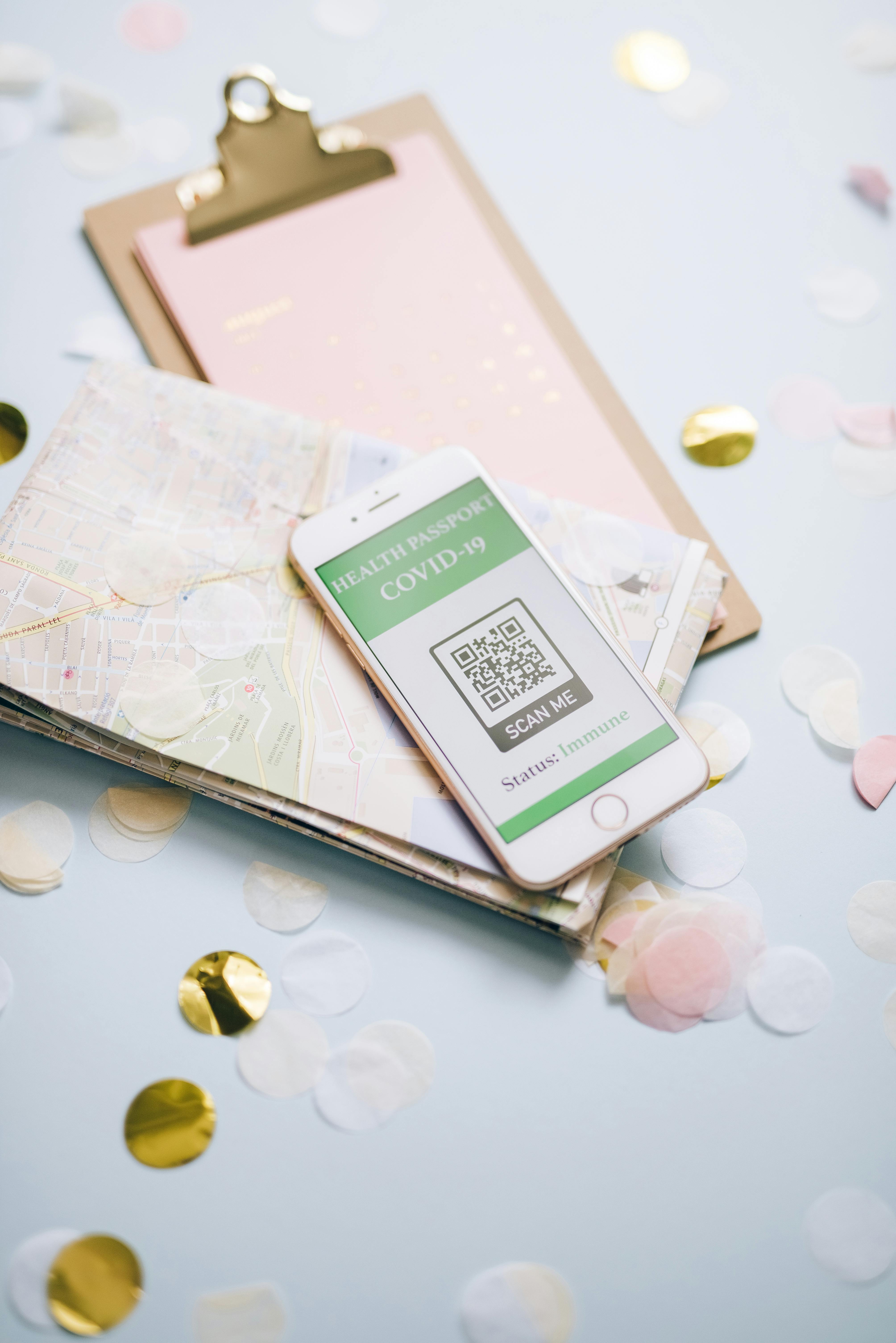 Smartphone displaying COVID-19 health passport on a map with confetti.