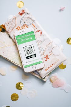 Smartphone displaying COVID-19 health passport on map and confetti background.