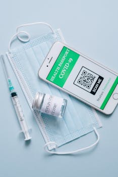 A health passport on smartphone with a mask, syringe, and vaccine vial.