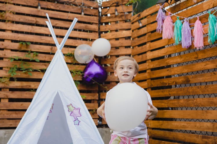 Child Holding A White Balloon