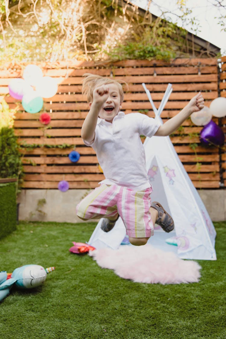 Kid Jumping Near A Teepee