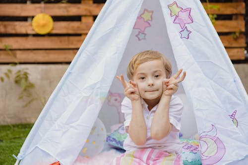 Free Close-Up Shot of a Boy Sitting inside the Tent Stock Photo