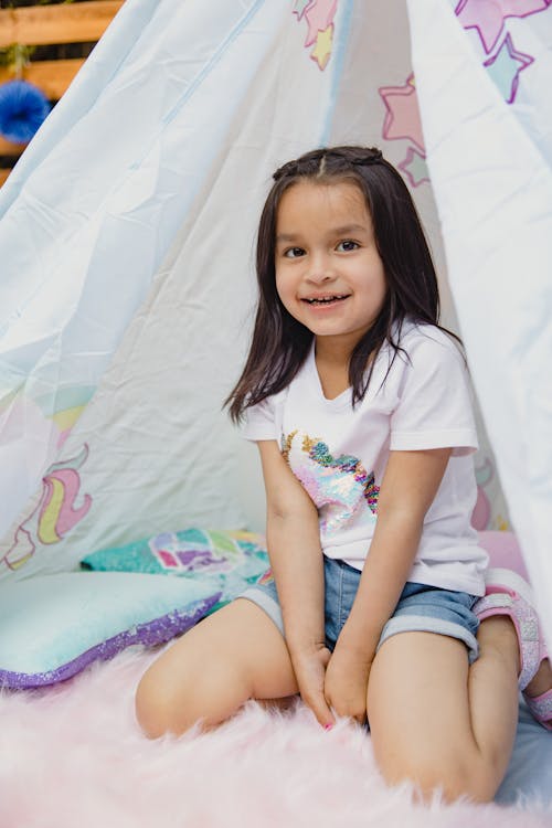 Girl in White Shirt Sitting Inside a Tepee