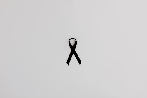 Free Black awareness ribbon symbolizing support and solidarity on a white background. Stock Photo