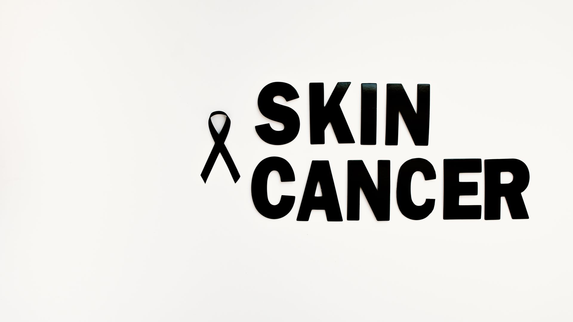 Modafinil for Cancer Related Fatigue: Unlocking Energy Black ribbon and text highlighting skin cancer awareness on a white background — modafinil for cancer related fatigue