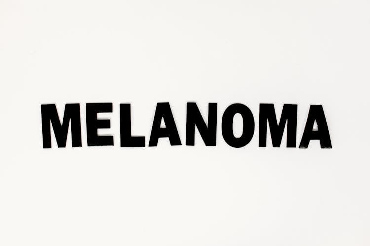 A Black Melanoma Text On White Surface