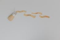 Text Saying "Dont Skin the Sunscreen" and a Bottle with Sunscreen Lying on White Background