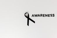 Conceptual image of a black ribbon with 'awareness' text on white background.