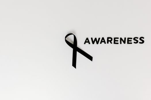 Conceptual image of a black ribbon with 'awareness' text on white background.