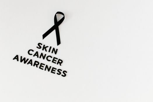 Black ribbon and text promoting skin cancer awareness on a white background.