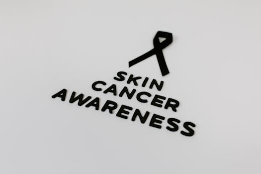 Black ribbon symbolizing skin cancer awareness on a white background.