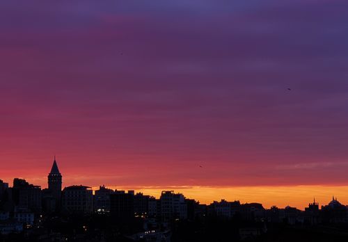 Free Silhouette of city skyline with a vibrant, colorful sunset sky, highlighting an iconic tower. Stock Photo