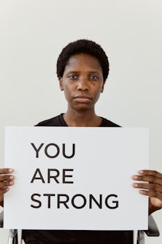 Portrait of a person holding a sign with an empowering message.