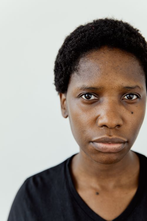 Free Detailed close-up portrait of a black woman against a plain background. Stock Photo