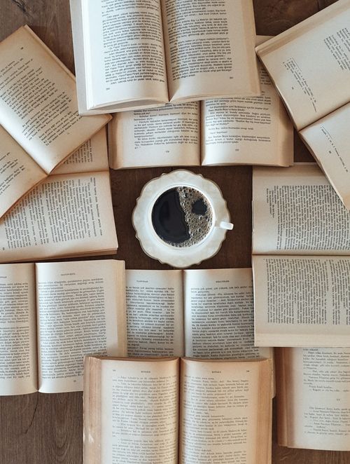 Free Flat lay of open books surrounding a coffee cup, perfect for a relaxing reading atmosphere. Stock Photo